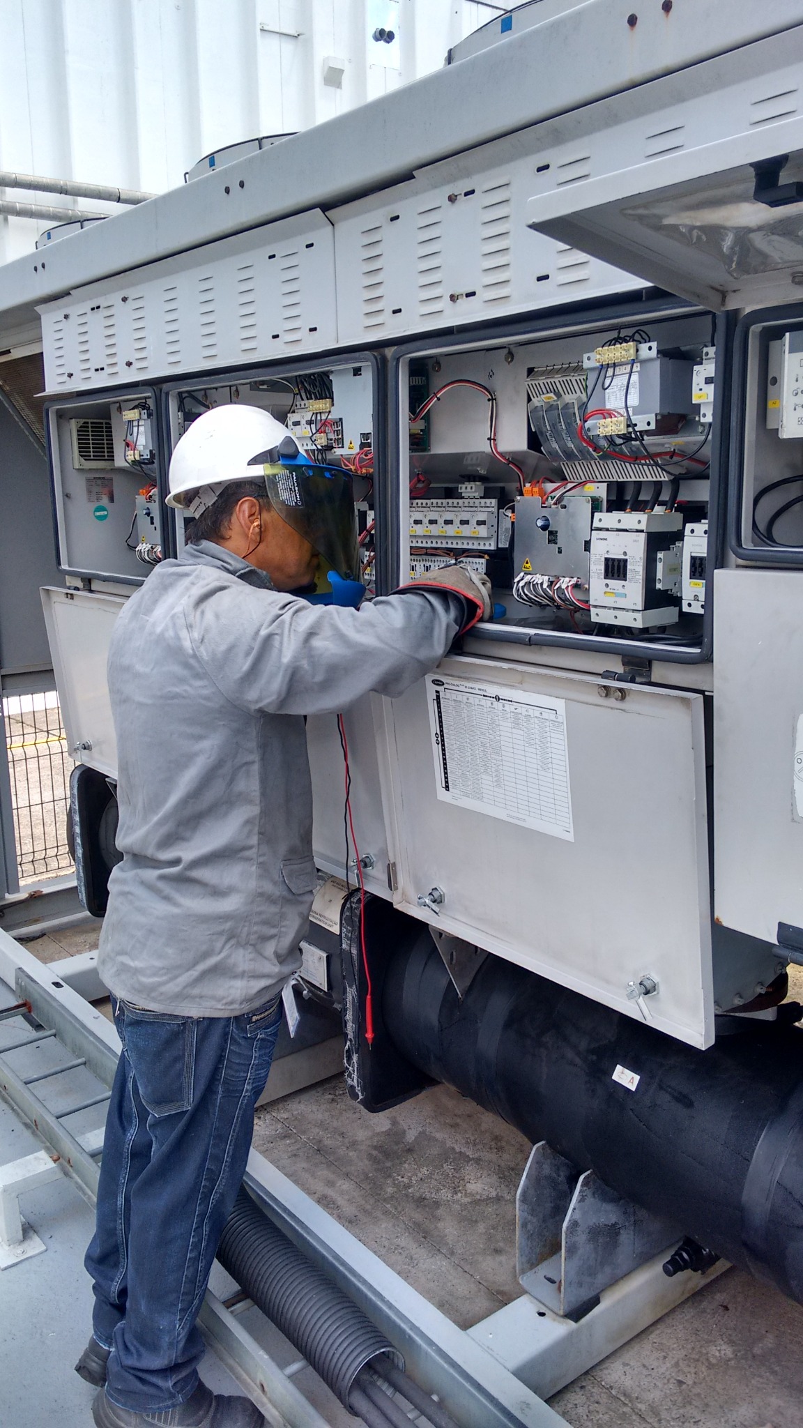 Técnico realizando manutenção elétrica em painel