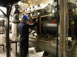 Técnico ao lado de chiller parafuso